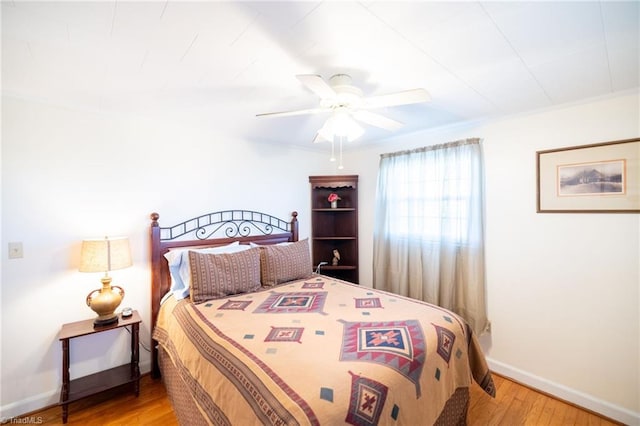 bedroom featuring a ceiling fan, light wood-style flooring, and baseboards