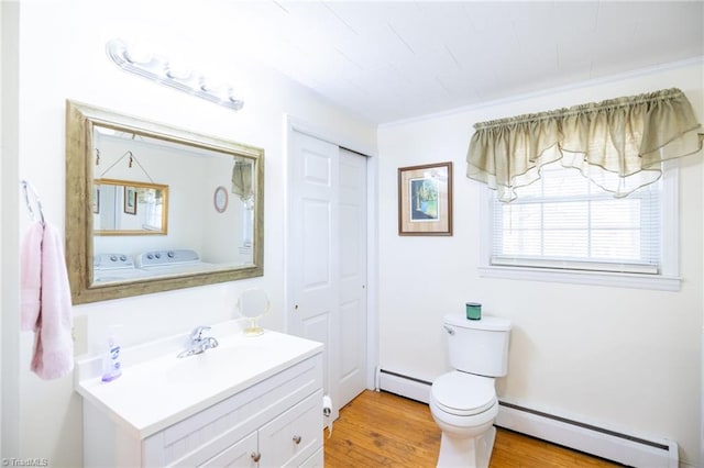 half bath with toilet, a baseboard heating unit, washer and clothes dryer, and vanity