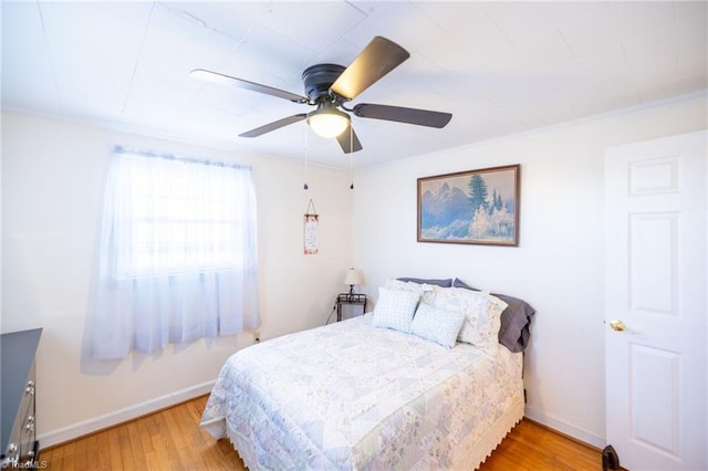 bedroom with a ceiling fan, baseboards, and wood finished floors