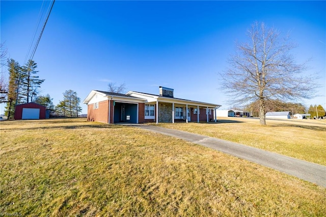 view of front facade featuring a garage, brick siding, a chimney, and a front yard