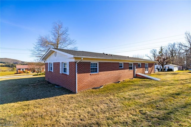 view of home's exterior featuring a lawn and brick siding