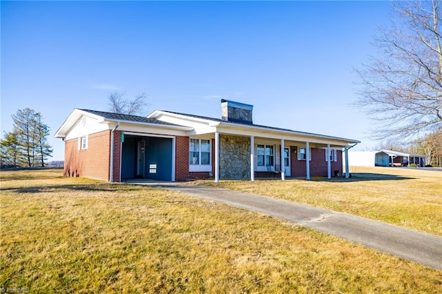 view of front of home with a porch, a front yard, brick siding, and a chimney