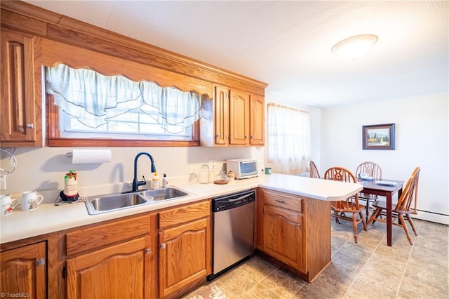 kitchen with a peninsula, a sink, light countertops, stainless steel dishwasher, and brown cabinets