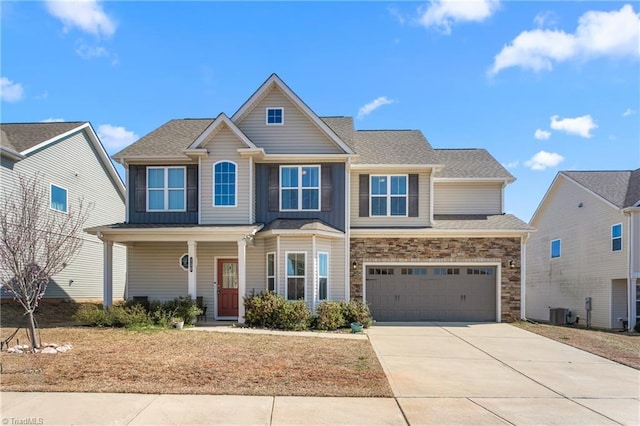 view of front of house with driveway, stone siding, cooling unit, covered porch, and a garage