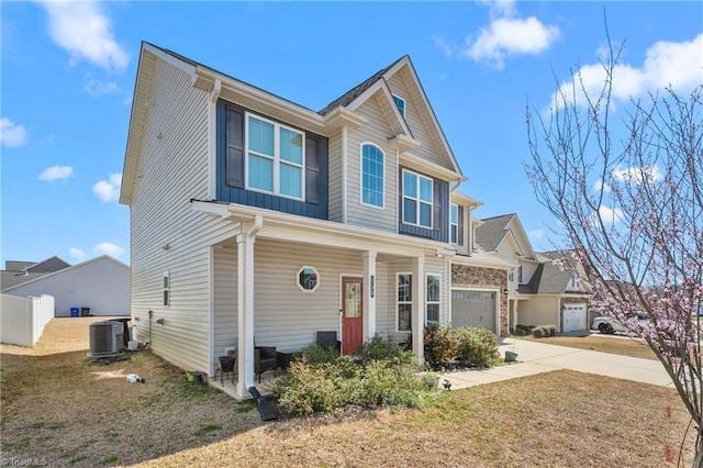 view of front facade with a front lawn, fence, concrete driveway, cooling unit, and a garage