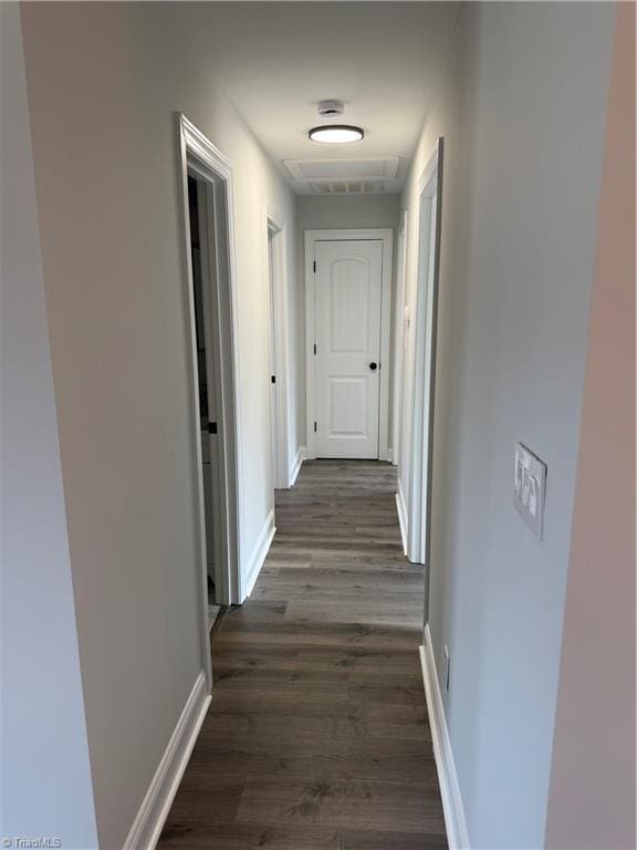 corridor with baseboards and dark wood finished floors