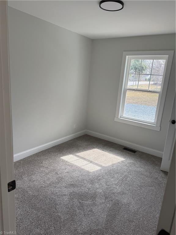 unfurnished room with visible vents, baseboards, and carpet flooring