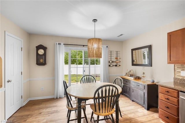 dining room featuring light wood-style floors, visible vents, and baseboards