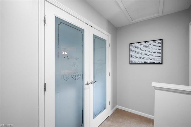 interior space with light colored carpet, french doors, and baseboards