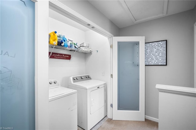 washroom featuring separate washer and dryer, light colored carpet, laundry area, and baseboards