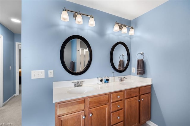 bathroom with double vanity, a sink, and baseboards