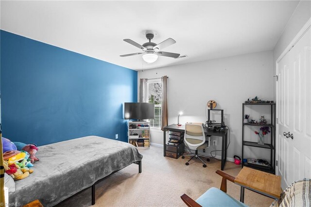 carpeted bedroom featuring ceiling fan, visible vents, and baseboards