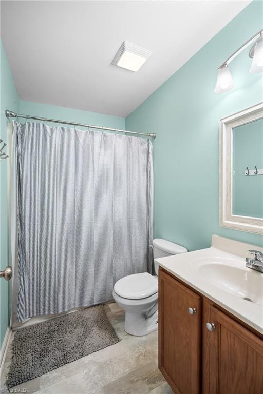 bathroom featuring curtained shower, toilet, and vanity