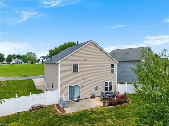 back of property featuring a lawn, a fenced backyard, and a patio area