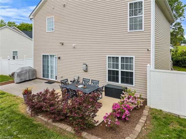 rear view of house featuring fence and a patio area