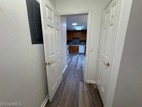 hall with dark wood-type flooring, baseboards, and electric panel