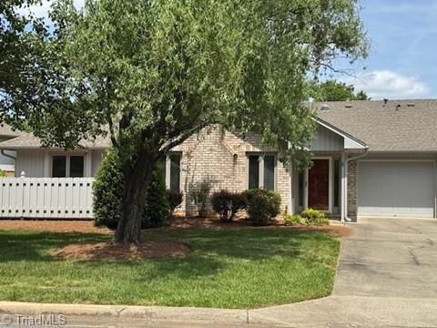 view of front of property with a garage, fence, a front lawn, and aphalt driveway