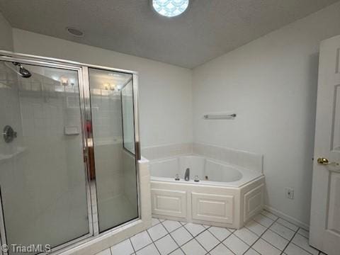bathroom featuring tile patterned floors, a tub with jets, and a stall shower