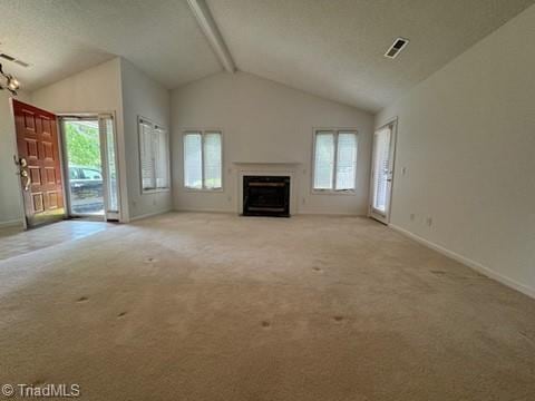 unfurnished living room with a fireplace with flush hearth, plenty of natural light, and carpet