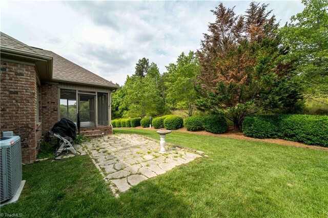 2334 Addison Blvd, High Point, NC 27262 - view of grassy yard with a sunroom, central air condition unit, and a patio area