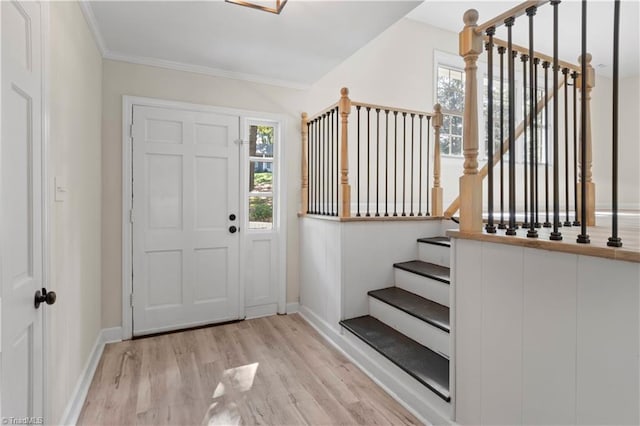 foyer entrance with light wood-type flooring and crown molding