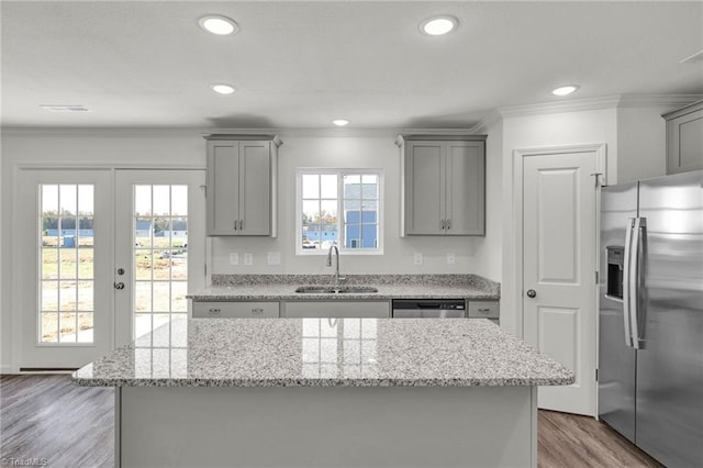 kitchen with a center island, french doors, sink, appliances with stainless steel finishes, and light hardwood / wood-style floors