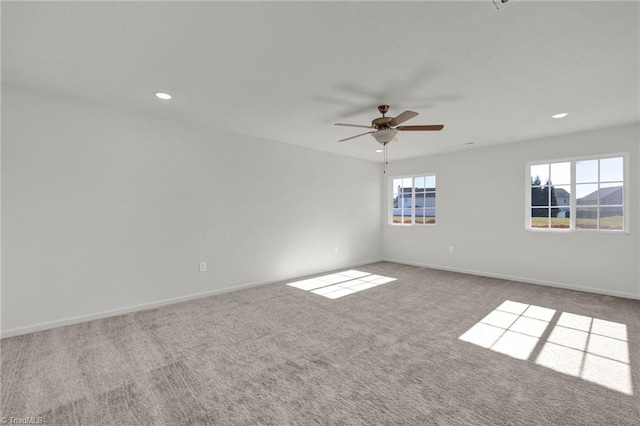 spare room with ceiling fan and light carpet