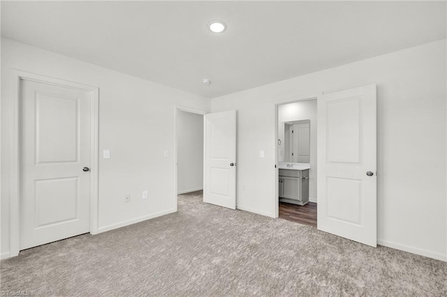 unfurnished bedroom featuring carpet flooring and connected bathroom