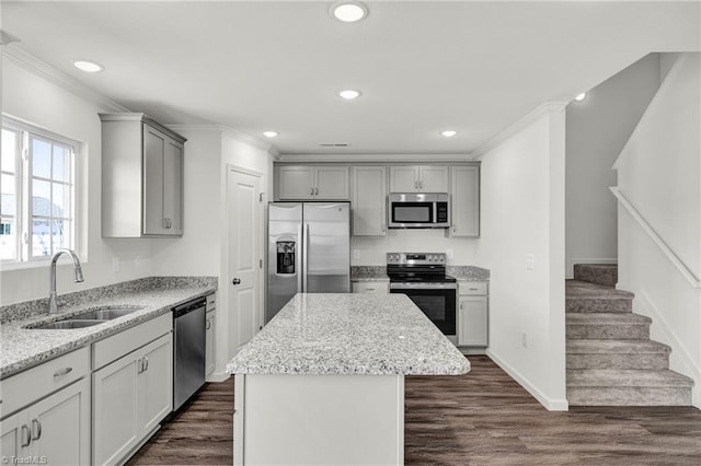 kitchen with light stone countertops, sink, a kitchen island, and stainless steel appliances