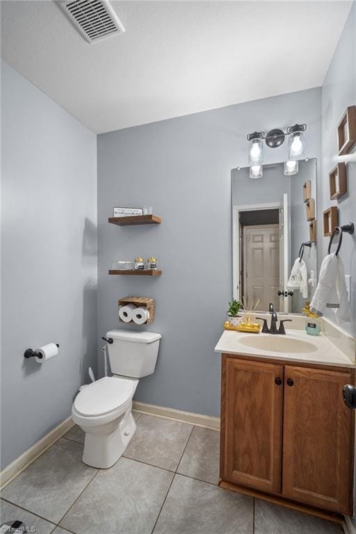 bathroom with tile patterned flooring, visible vents, vanity, toilet, and baseboards