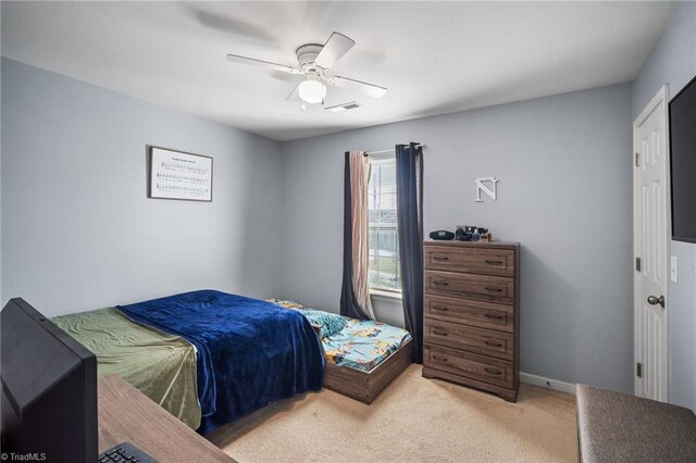 carpeted bedroom with baseboards, a ceiling fan, and visible vents