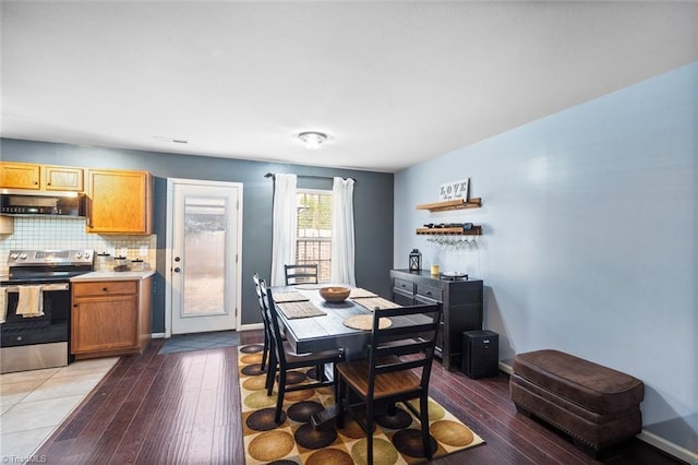 dining room with baseboards, a bar, and hardwood / wood-style flooring