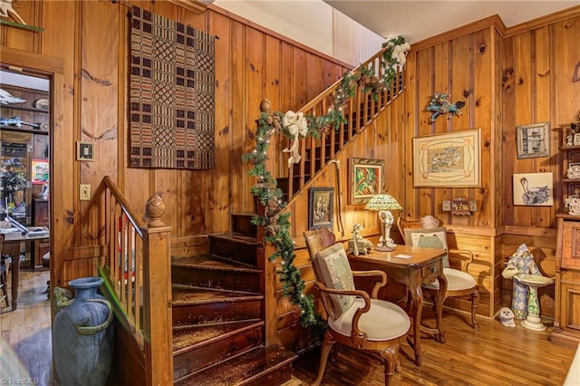 staircase featuring hardwood / wood-style flooring and wooden walls