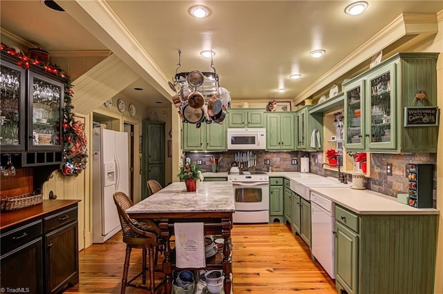 kitchen with ornamental molding, sink, white appliances, and green cabinetry