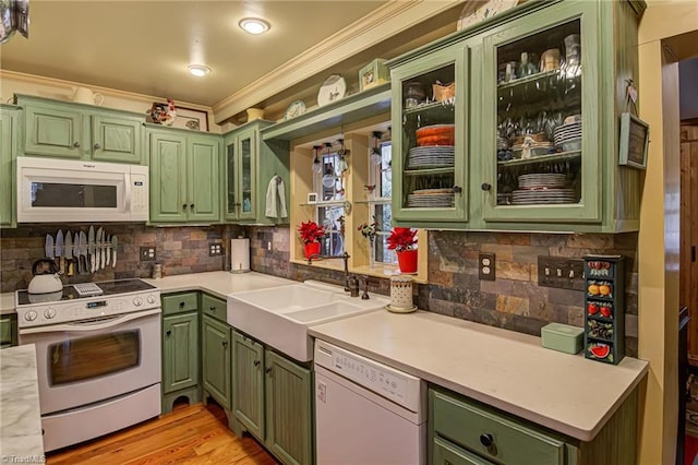 kitchen with sink, green cabinets, and white appliances