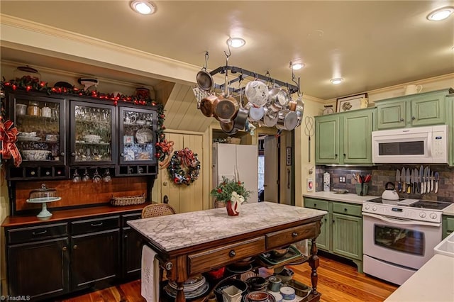 kitchen with crown molding, hardwood / wood-style floors, white appliances, and tasteful backsplash