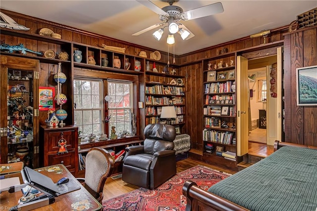 office space featuring hardwood / wood-style floors, ceiling fan, and wood walls