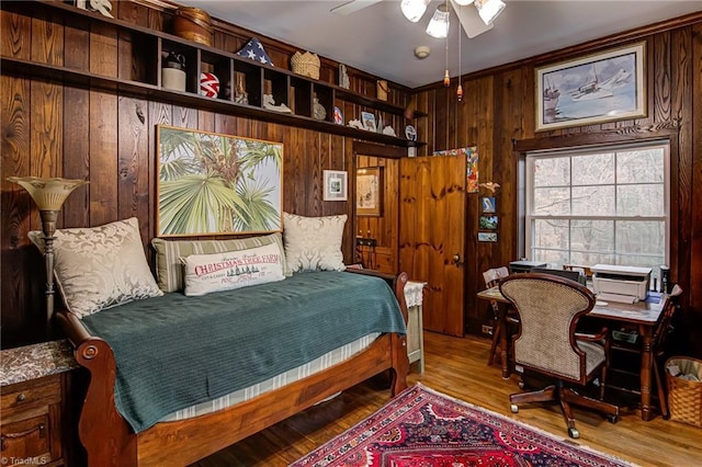 bedroom featuring light hardwood / wood-style flooring and wooden walls