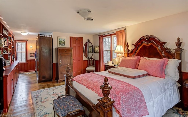 bedroom featuring hardwood / wood-style floors, a closet, and wood walls