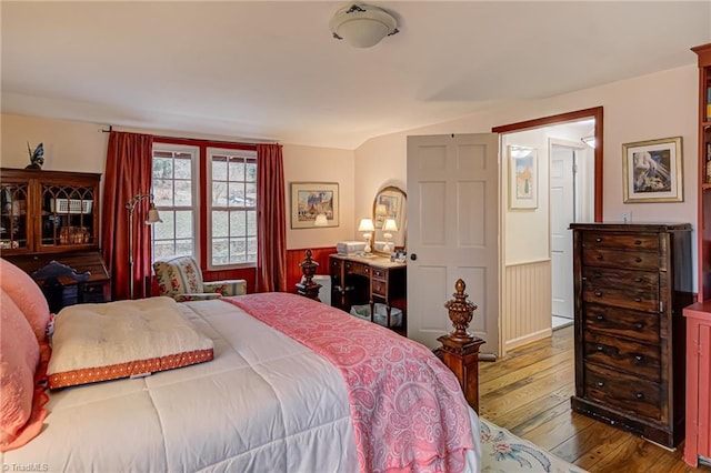 bedroom with lofted ceiling and hardwood / wood-style floors