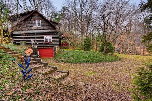 view of yard with a garage and central air condition unit