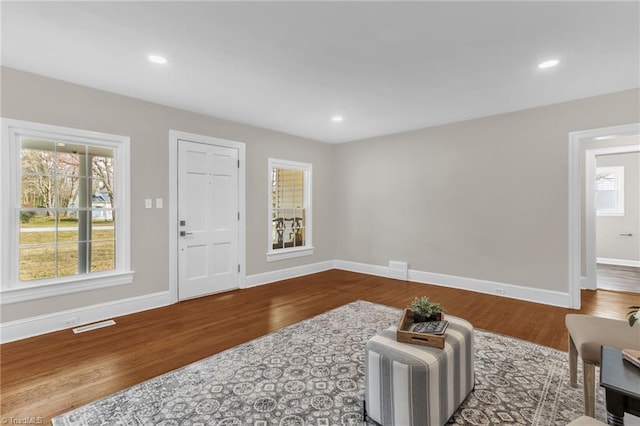 living area with recessed lighting, wood finished floors, and baseboards