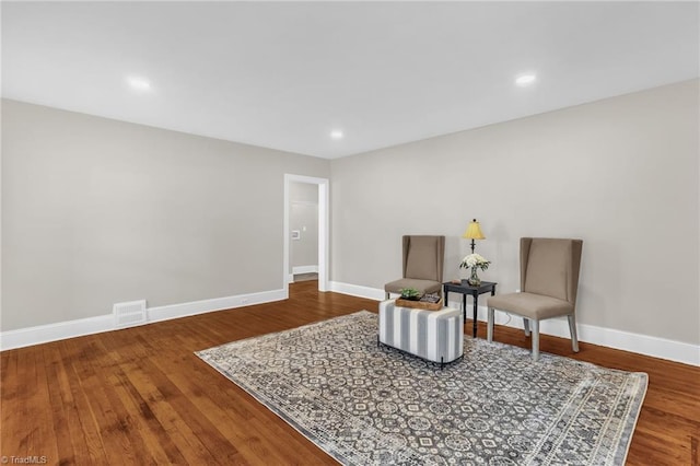 living area with baseboards, visible vents, wood finished floors, and recessed lighting