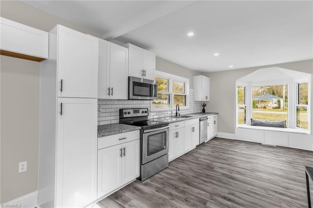 kitchen featuring stainless steel appliances, dark wood-style flooring, backsplash, and white cabinets