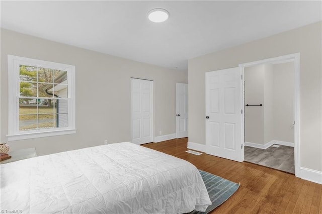 bedroom featuring a closet, wood finished floors, and baseboards