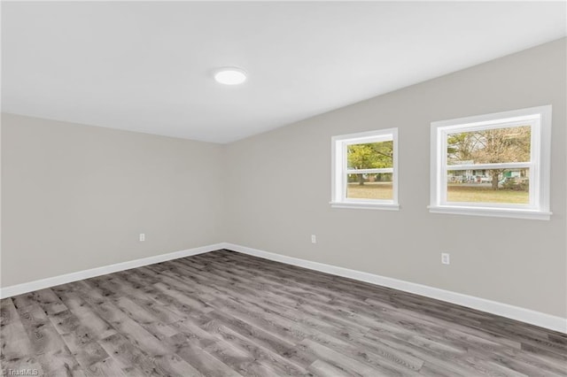 unfurnished room with wood finished floors and baseboards