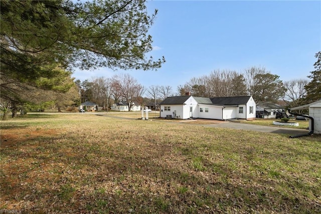 view of yard featuring a garage and aphalt driveway