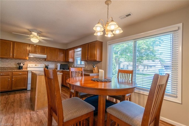 136 Fairway Dr, Bermuda Run, NC 27006 - dining area featuring a chandelier, wood finished floors, and a ceiling fan