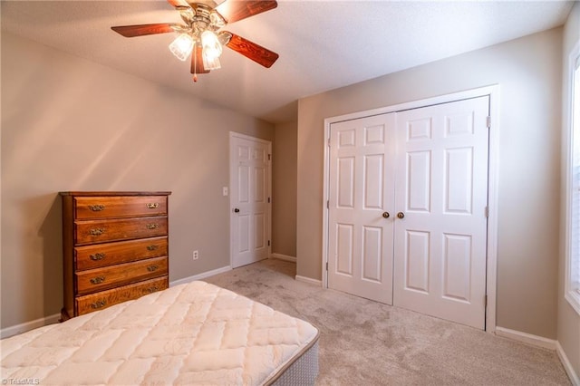 unfurnished bedroom featuring a closet, ceiling fan, and light colored carpet