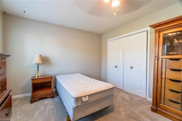 carpeted bedroom with ceiling fan and a closet